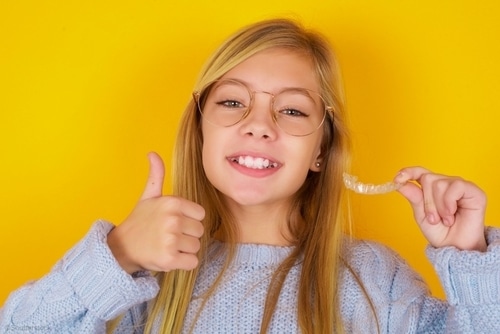CSS blonde young girl holding clear aligners RESIZED